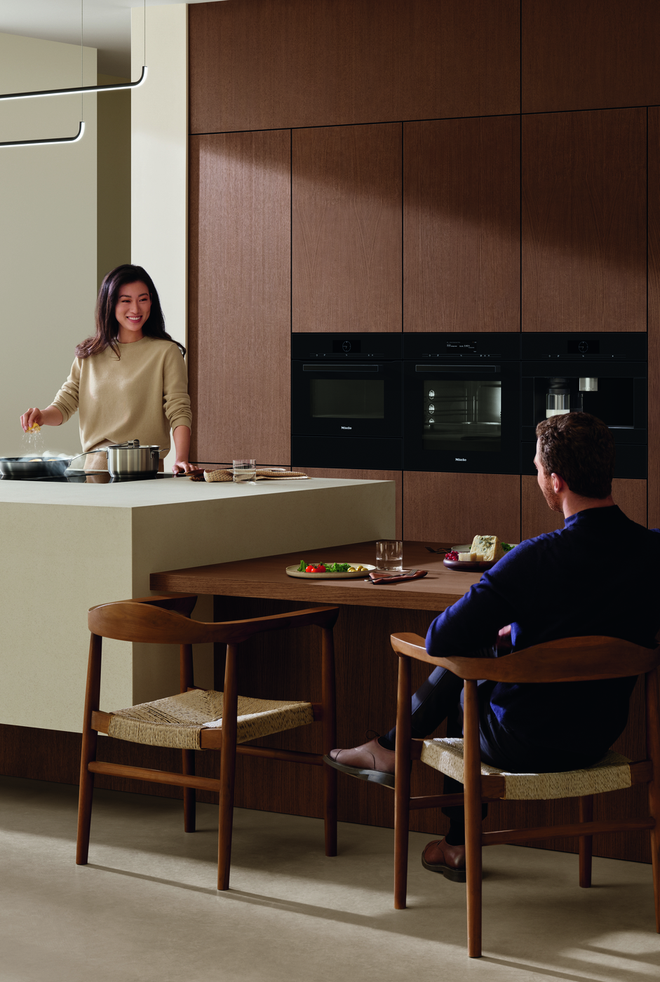 Double Oven and Built-In Microwave in Kitchen With Man and Woman