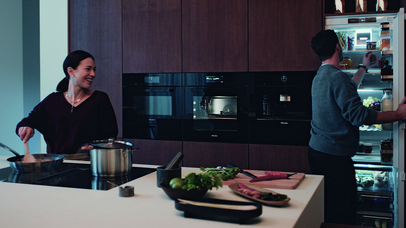 Woman and Man Cooking using Miele Kitchen Appliances